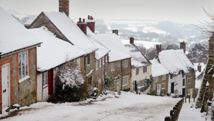 Snow-covered cottages along a steep village street in winter