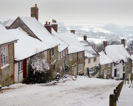Snow-covered cottages along a steep village street in winter