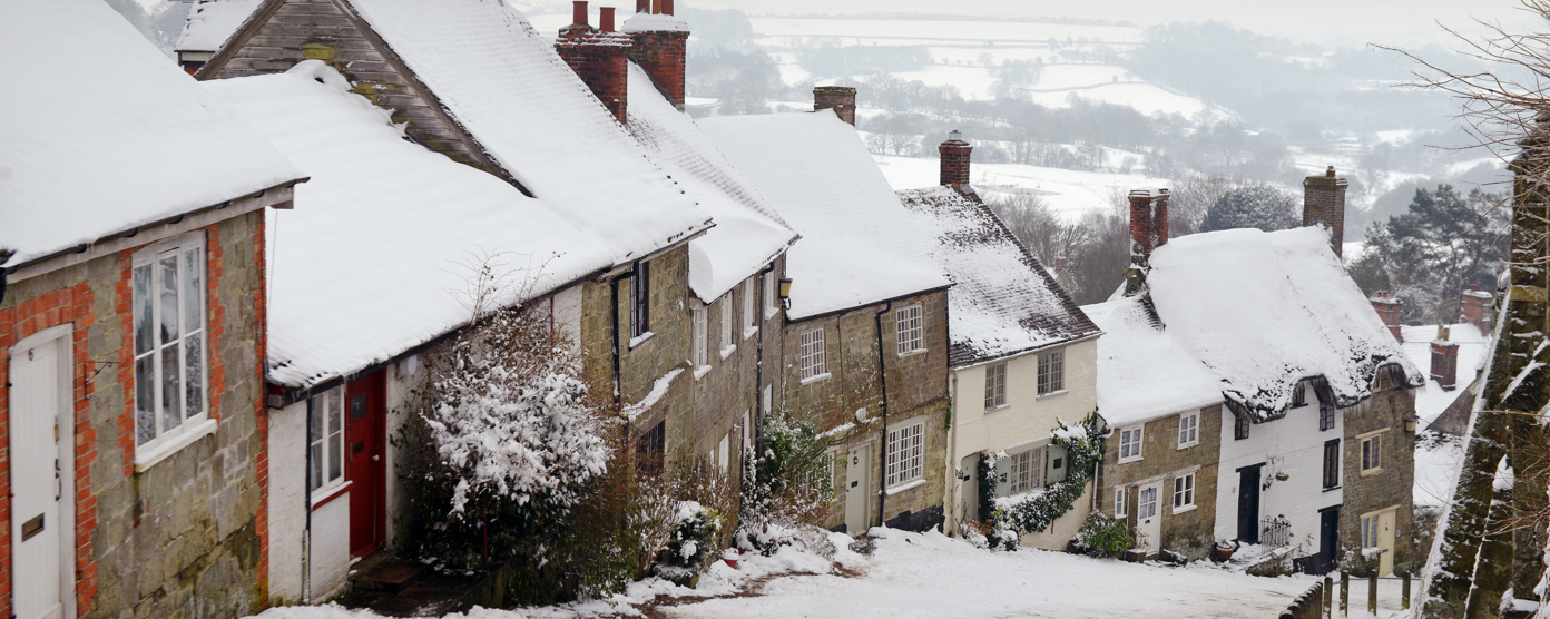 Snow-covered cottages along a steep village street in winter