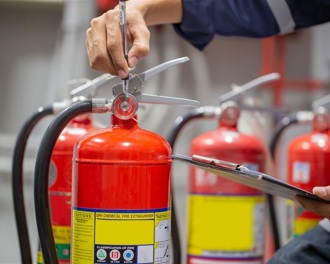 Close up of a hand holding a red fire extinguisher