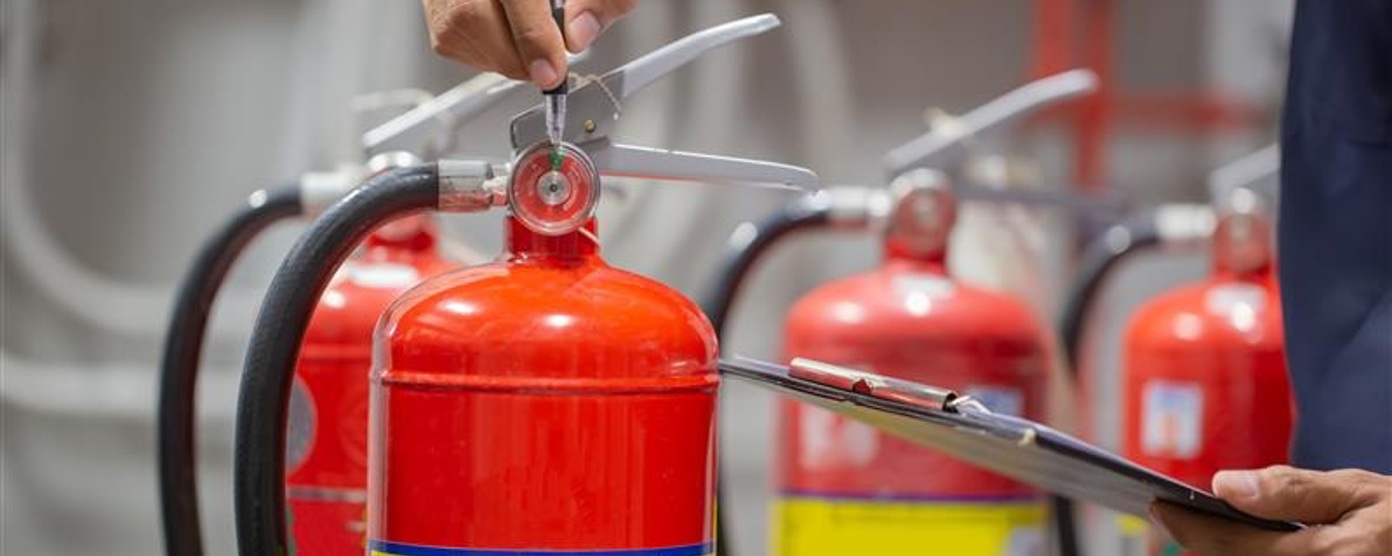 Close up of a hand holding a red fire extinguisher