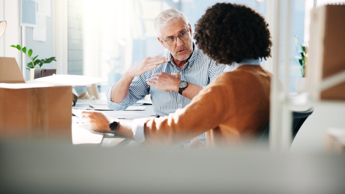 A male and female colleague conversing in an office