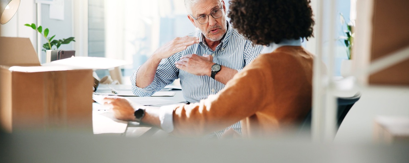 A male and female colleague conversing in an office