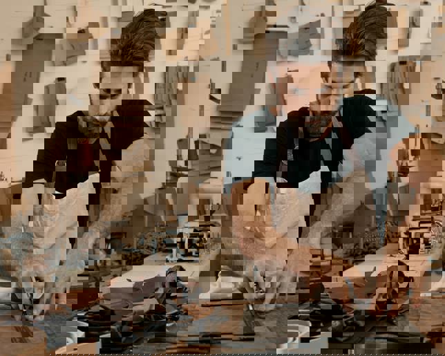 Cropped shot of a young artisan working with leather