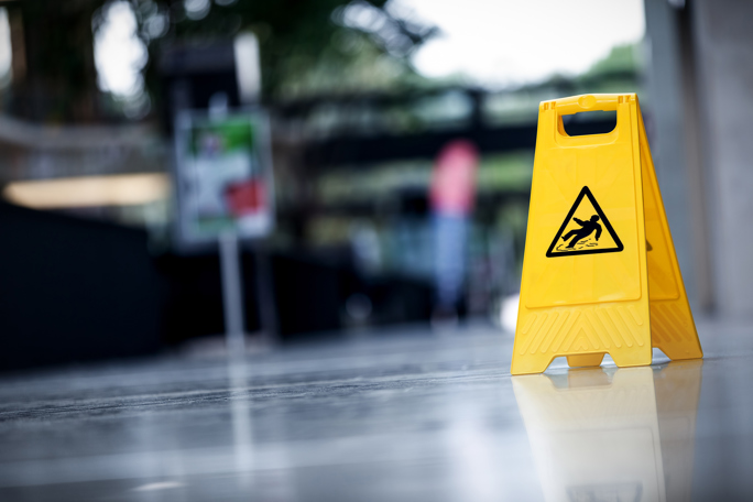 A caution sign in bright yellow reading  "Wet Floor," alerting individuals to potential slip hazards on a wet surface.