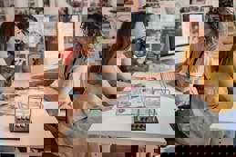 Couple consulting with a travel agent at a travel agency desk, discussing holiday or vacation plans