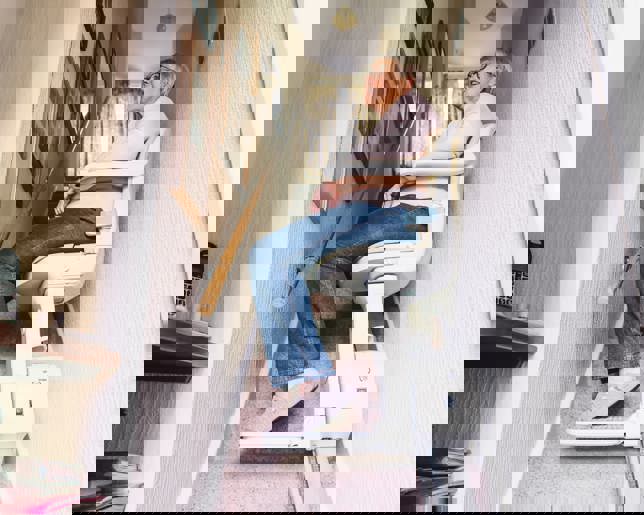 Senior woman using automatic stair lift home