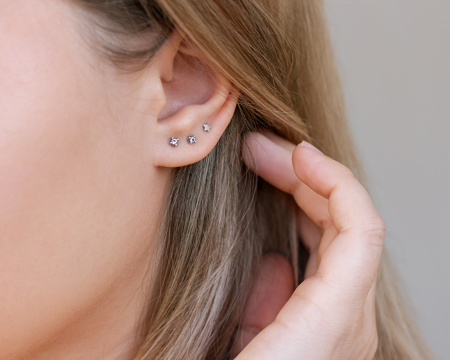 Triple stud ear piercing gemstone jewelry on the earlobe