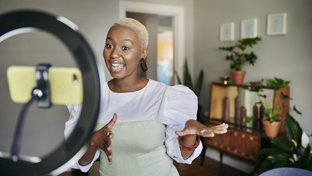 Content creator recording video with phone and ring light.