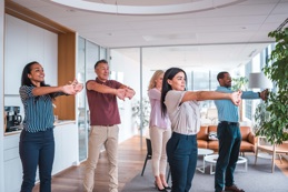 Colleagues doing yoga in an office
