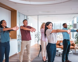 Colleagues doing yoga in an office