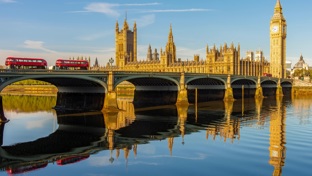 Houses of parliament with red buses in the foreground