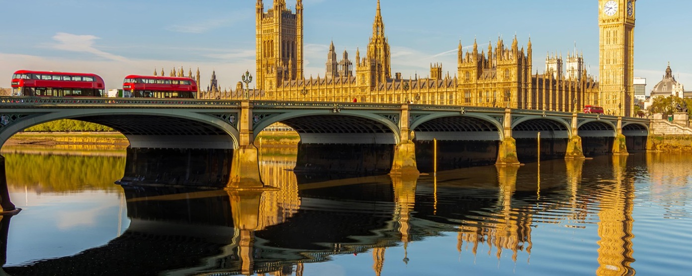 Houses of parliament with red buses in the foreground