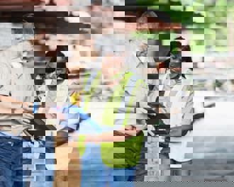 Two multiracial workers working at a lumberyard