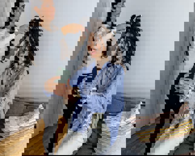 Hairdresser is using a hair dryer