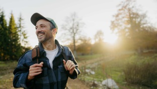 man walking outside and smiling