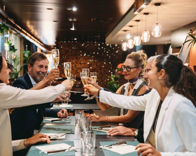 A group of friends clinking champagne flutes in a restaurant