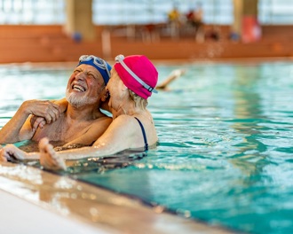 Mature couple laughing in a swimming pool