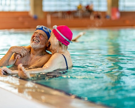 Mature couple laughing in a swimming pool
