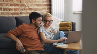 A man and a woman are talking about a topic while looking at the laptop.