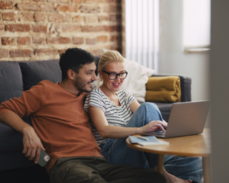 A man and a woman are talking about a topic while looking at the laptop.