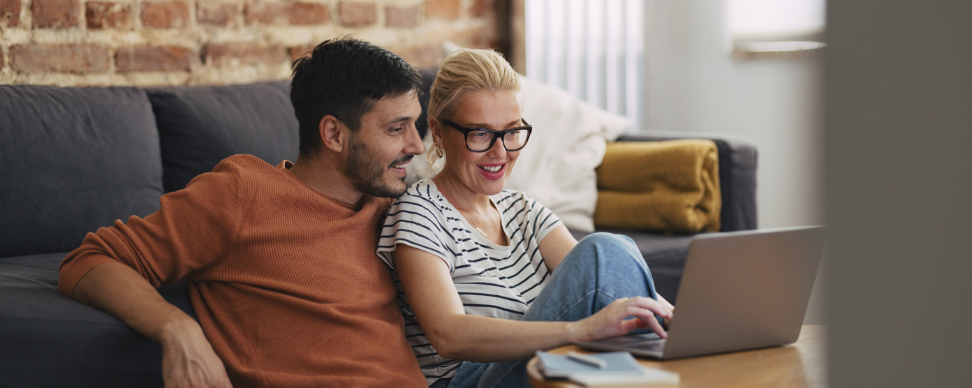 A man and a woman are talking about a topic while looking at the laptop.