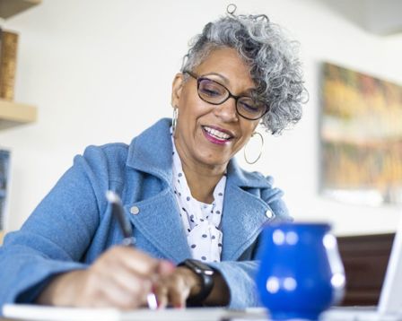 Professional woman taking notes while sitting at a table