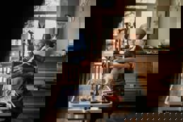 Female pet groomer trimming fur on a grooming table in a professional pet salon, providing expert care and stylish grooming.