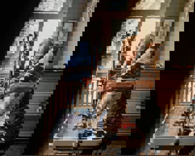 Female pet groomer trimming fur on a grooming table in a professional pet salon, providing expert care and stylish grooming.