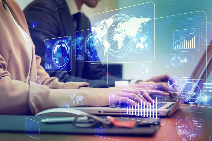  Business professionals working on laptops with futuristic holographic analytics, world map, and data charts overlaying a modern office scene
