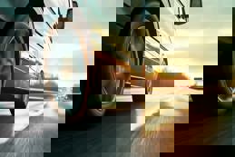 Car rushes along the highway at sunset