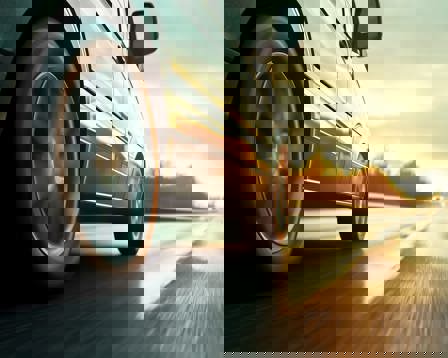 Car rushes along the highway at sunset