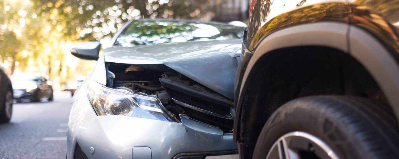 Close up of a car bonnet crushed against another car on a road