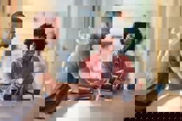 Female agent working on laptop with her customer in the office