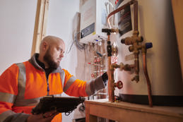 Plumber installing and inspecting a home heating system