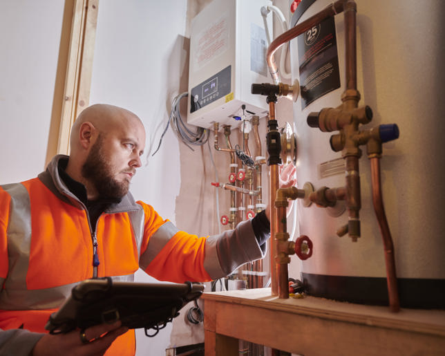 Plumber installing and inspecting a home heating system
