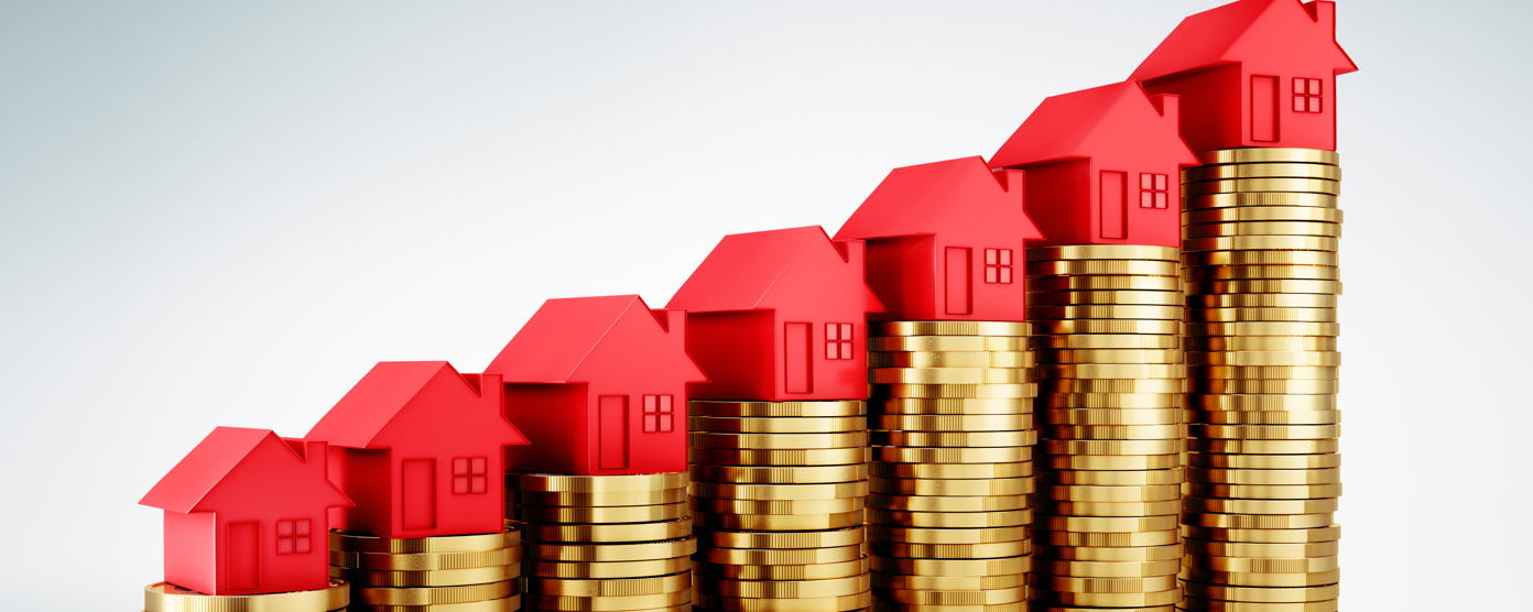 Stacks of golden coins topped with red houses illustrate rising real estate values or investment growth.