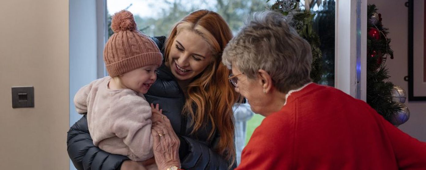 Family being greeted as they enter the front door