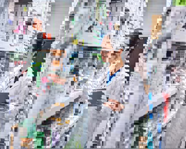 Pharmacist managing inventory with tablet