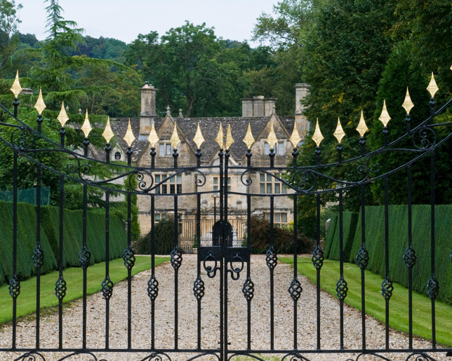 driveway-to-large-historic-manor-house-through-ornate-gates.jpg