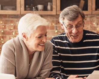 A mature couple looking at paperwork in the kitchen