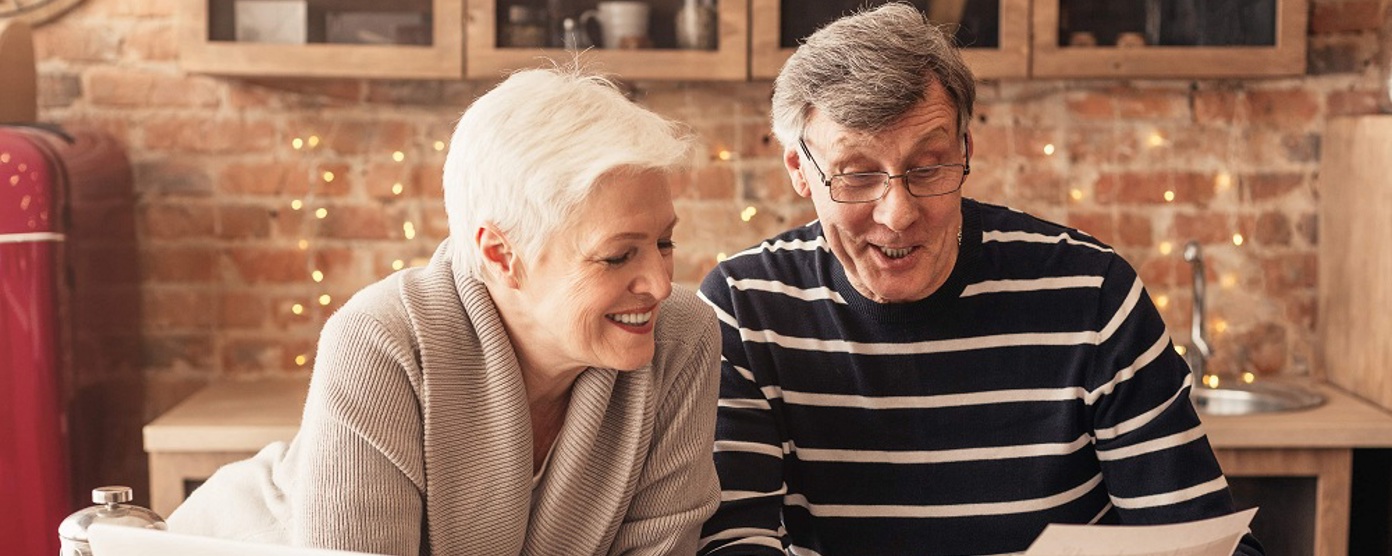 A mature couple looking at paperwork in the kitchen