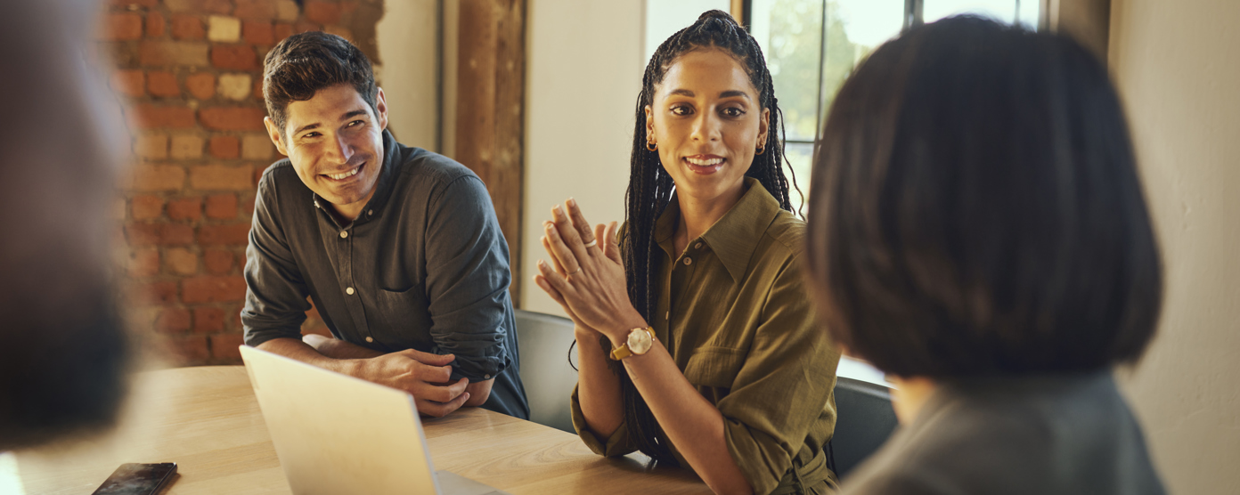 A group meeting where you can see two people listening happily to the person talking 