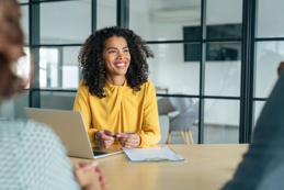 Candidate presenting their resume during a job interview with a panel of professionals in a formal business meeting setting.