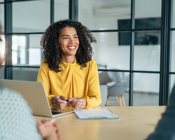 Candidate presenting their resume during a job interview with a panel of professionals in a formal business meeting setting.