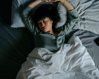 A woman asleep on her back in bed