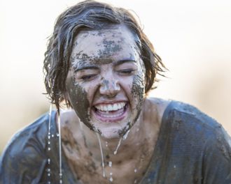 Woman laughing as she is wet doing a mud run
