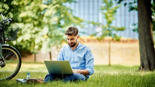 man using his laptop in a park