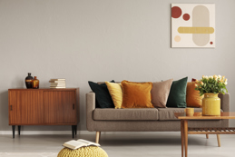 Modern living room with a neutral-toned sofa, colorful throw pillows.