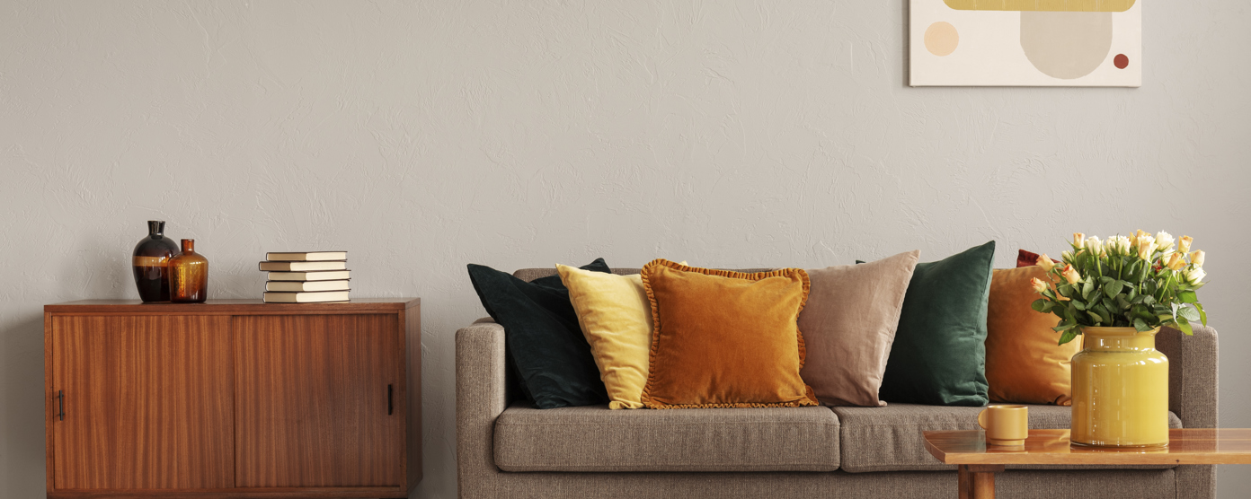 Modern living room with a neutral-toned sofa, colorful throw pillows.
